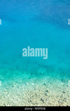 Una veduta aerea di acqua limpida e turqouise, blu e aqua colori del mare Ionio visto in spiaggia Foki di Cefalonia, Grecia. Foto Stock