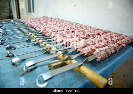 Lula kebab spiedini su , tradizionale piatto caucasico, close-up . Appetitosi kebab di lula alla griglia su spiedino di metallo. La cottura della carne. Foto Stock