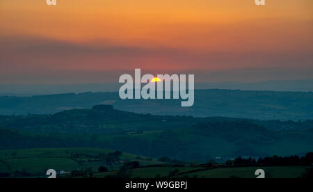 Tramonto dietro il rotolamento colline gallesi, visto dal Stiperstones, Shropshire Foto Stock