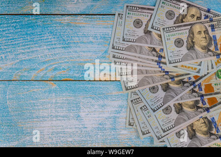 Un centinaio di dollari su uno sfondo blu. Banconote da cento dollari. Foto Stock