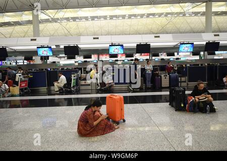 Hong Kong, Cina. 13 Ago, 2019. I turisti sono bloccate a causa di caos provocato dai manifestanti all'Aeroporto Internazionale di Hong Kong a Hong Kong, Cina del sud, e il agosto 13, 2019. Manifestanti hanno creato il caos all'Aeroporto Internazionale di Hong Kong per la seconda giornata di martedì, causando la cancellazione della maggior parte dei voli di andata in corrispondenza di uno degli aeroporti più trafficati del mondo. Credito: Lui Siu Wai/Xinhua/Alamy Live News Foto Stock