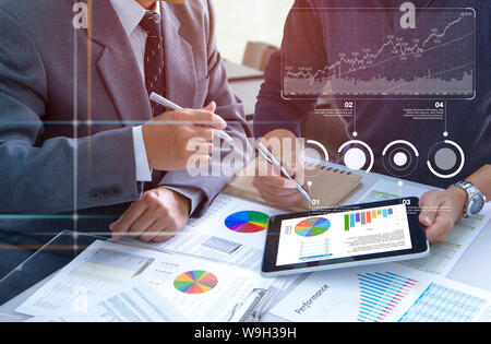 Due imprenditori sono profondamente rivedendo i report finanziari per un ritorno sugli investimenti o il rischio di investimento e di analisi delle prestazioni aziendali. Foto Stock
