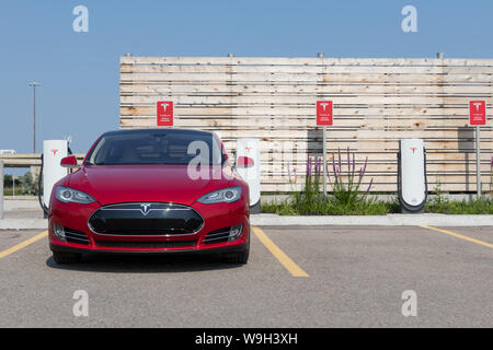 Parte anteriore del Rosso Modello Tesla S durante la carica a Tesla sovralimentatore urbano. Foto Stock