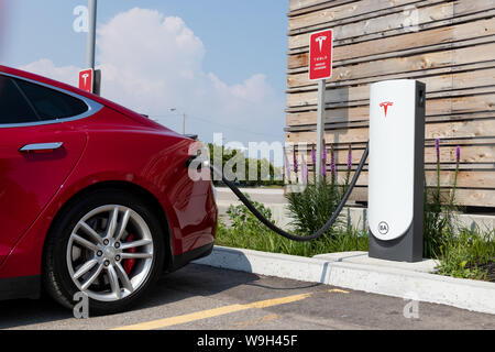 Tesla sovralimentatore urbano a CF Sherway Gardens Mall con Tesla Model S collegata a una presa di corrente e la ricarica. Foto Stock