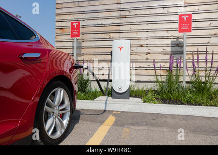 Tesla sovralimentatore urbano a Toronto (Etobicoke) con Tesla Model S ricarica. Foto Stock