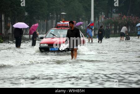 I residenti locali e di automobili sulle strade allagate nella città di Xiangfan, porcellane centrale provincia di Hubei 14 luglio 2007. Più di 400 persone sono state uccise e Foto Stock