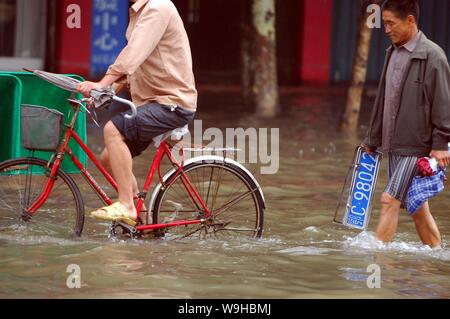 I residenti locali sulle strade allagate nella città di Xiangfan, porcellane centrale provincia di Hubei 14 luglio 2007. Più di 400 persone sono state uccise e oltre 100 Foto Stock