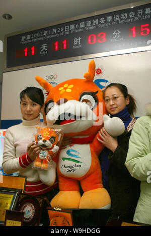 Due ragazze cinesi posano con una mascotte ufficiale del prossimo Sesto dei Giochi Invernali Asiatici in Changchun, capitale del nord-est Chinas provincia di Jilin, 16 Janu Foto Stock