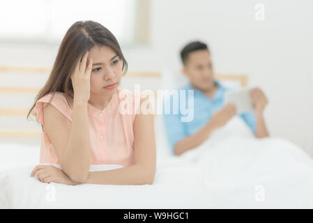 Giovani asiatici giovane amante aventi argomento e litigi, ragazzo utilizzare smart tablet ignorato la sua ragazza. Foto Stock