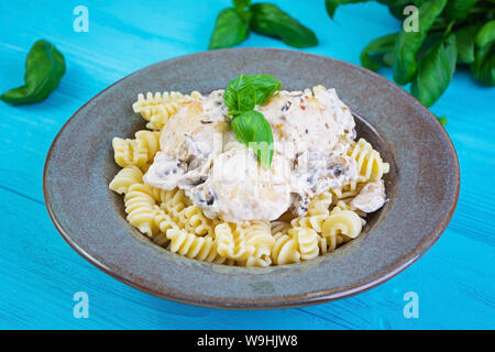 Polpette con fusilli, la crema di latte e funghi su sfondo di legno Foto Stock