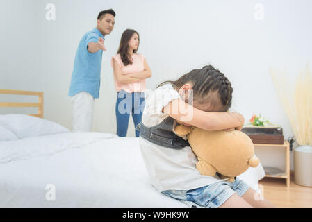 Asian bambina tristezza mentre il genitore litigi in camera da letto.Foto design per problemi familiari e di concetto infelice. Foto Stock