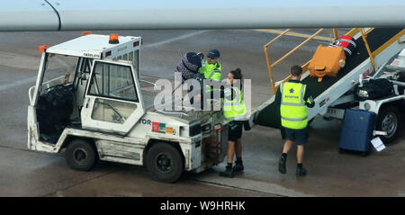 Bagagli in pista al terminal di un aeroporto di Manchester. Foto Stock