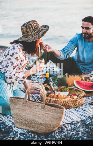 Giovane donna di alimentazione con fragola durante il picnic estivo Foto Stock