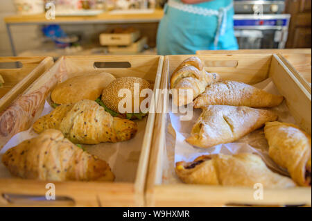 Cornetti e gli hamburger sul contatore in panetteria. I croissant su un basket weave in un panificio. Foto Stock