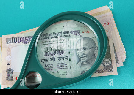 Banconote indiano visto attraverso la lente di ingrandimento Foto Stock
