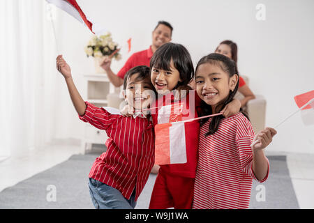 Famiglia indonesiano holding indonesia bandiera su sfondo bianco Foto Stock