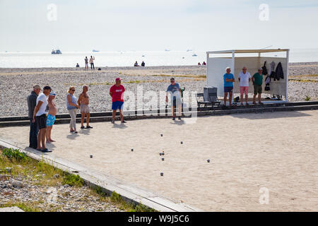 Un gruppo di persone che giocano una partita a bocce o petanques sulla spiaggia sul lungomare di Le Havre, Normandia, Francia Foto Stock