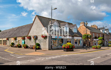 ALNESS Ross and Cromarty SCOZIA VILLAGE CITTÀ IN FIORE eccellente display di fiori colorati sui negozi di High Street Foto Stock