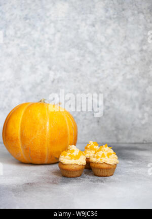 Tortini di zucca su uno sfondo grigio chiaro, autunno sfondo zucche e foglie. I dolci di zucca. Halloween e dolci di ringraziamento Foto Stock