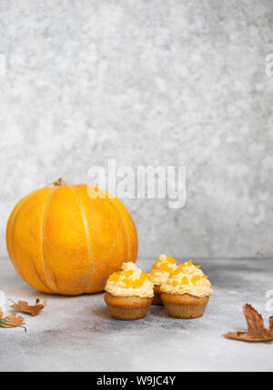 Tortini di zucca su uno sfondo grigio chiaro, autunno sfondo zucche e foglie. I dolci di zucca. Halloween e dolci di ringraziamento Foto Stock