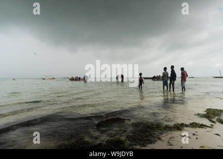I pescatori a bassa marea sulla costa est di Zanzibar Foto Stock