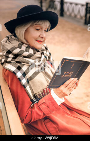 Ritratto di un elegante signora anziana libro lettura in posizione di parcheggio Foto Stock