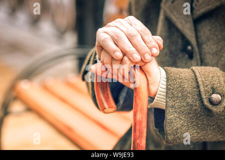 Close up di mani di uomo anziano appoggiato su di canna da zucchero Foto Stock