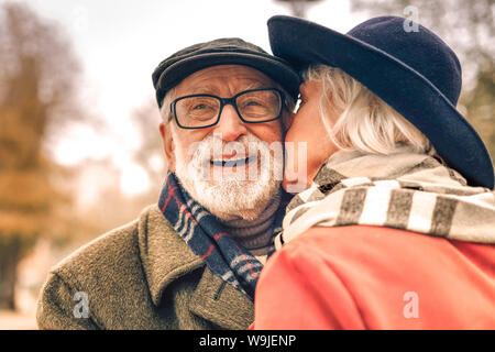 In prossimità di una felice coppia sorridente kissing in posizione di parcheggio Foto Stock