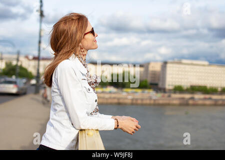 Giovane donna redhead godendo soleggiata giornata autunnale a Budapest, Ungheria Foto Stock