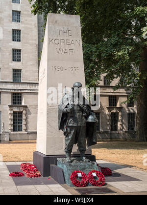 LONDRA, Regno Unito: Il Korean War Memorial (di Philip Jackson) in Victoria Embankment Gardens con le corone di papavero Foto Stock