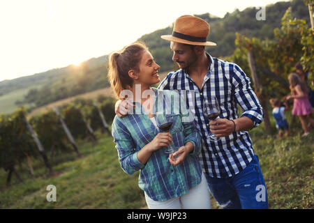 Donna e uomo in vigna bere il vino Foto Stock