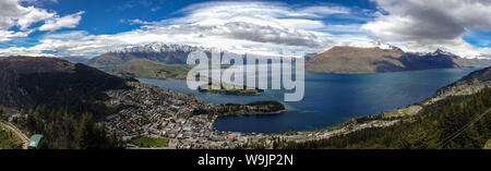 Un panorama di Queenstown e il Lago Wakatipu presi dalla Skyline lookout alta sopra Queenstown luminoso cielo blu Foto Stock