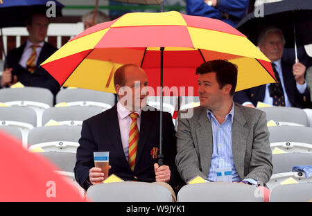 MCC membri riparo sotto un ombrello durante il giorno una delle ceneri Test match al Signore, Londra. Foto Stock