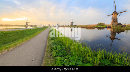 Panorama dei tipici mulini a vento si riflette nei canali all'alba, Kinderdijk, Sito Patrimonio Mondiale dell'UNESCO, Molenwaard, South Holland, Paesi Bassi Foto Stock