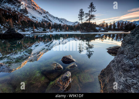 Autunno riflessi al Lago Saoseo ancora parzialmente congelato, Valle di Poschiavo, Cantone dei Grigioni, Svizzera, Europa Foto Stock