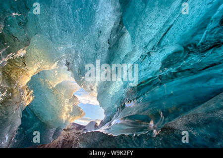 Vista dentro una caverna di ghiaccio sotto il sud ghiacciaio Vatnajokull, acquisite a sunrise durante la stagione invernale quando le grotte di ghiaccio sono accessibili, Jokulsarlon, Islanda Foto Stock