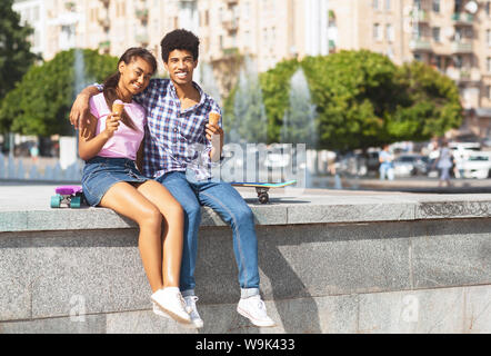 Allegro adolescenti aventi data in città a mangiare il gelato Foto Stock