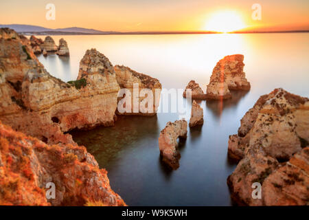 Golden sunrise sulle rocce rosse di Ponta da Piedade, Lagos, Algarve, Portogallo, Europa Foto Stock