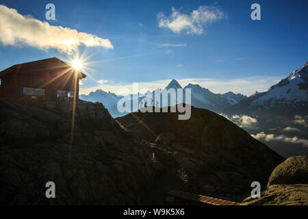 Gli escursionisti procedono verso il rifugio del Lac de Cheserys con il sole appena sorto, Chamonix Haute Savoie, sulle Alpi francesi, Francia, Europa Foto Stock