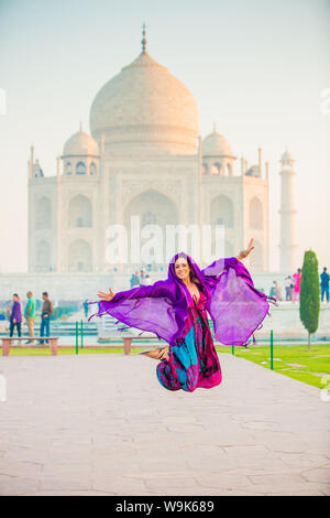 Laura Grier saltando al Taj Mahal, Sito Patrimonio Mondiale dell'UNESCO, Agra, Uttar Pradesh, India, Asia Foto Stock