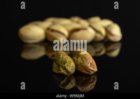 Sacco di tutto mature pistacchio verde in primo piano isolato sul vetro nero Foto Stock