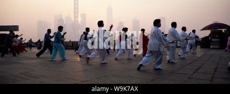 Persone che fanno la mattina presto t'ai chi esercita nel Parco di Huangpu sul Bund, Shanghai, Cina e Asia Foto Stock