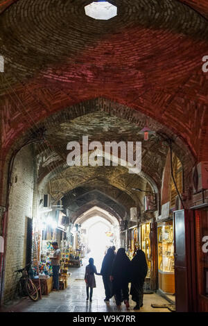 Ragazza e donne in nero lo chador, Gran Bazaar di Isfahan, Iran, Medio Oriente Foto Stock