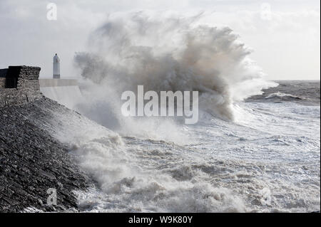 Onde infrangersi contro la parete del porto a Porthcawl, Bridgend, Wales, Regno Unito, Europa Foto Stock