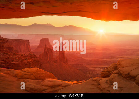 Sunrise oltre La Sal Mountains, Rondella donna Arch e Mesa Arch, Island in the Sky, il Parco Nazionale di Canyonlands, Utah, Stati Uniti d'America Foto Stock