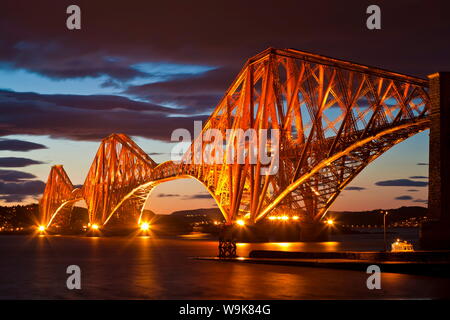 Ponte di Forth Rail oltre il Fiume Forth illuminata di notte, South Queensferry, Edimburgo, Midlothian, Scotland, Regno Unito, Europa Foto Stock