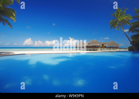 Piscina, palme e cabine, Maldive, Oceano Indiano, Asia Foto Stock