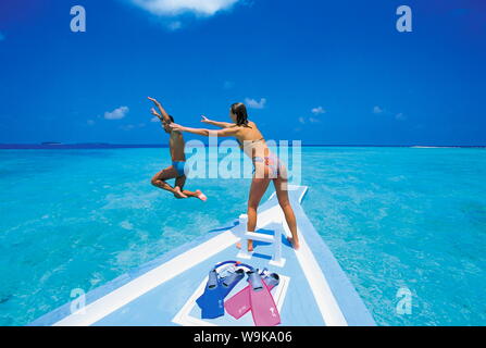 Matura in corrispondenza della parte anteriore della barca, uomo saltando in acqua, Maldive, Oceano Indiano, Asia Foto Stock