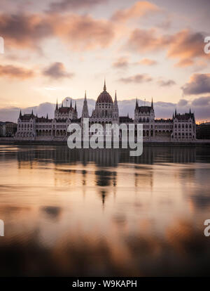 Sunrise dietro il Parlamento ungherese edificio e fiume Danubio, Budapest, Ungheria, Europa Foto Stock