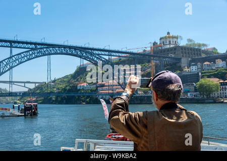 Turistica prendendo una foto sul suo telefono cellulare del Dom Luis Bridge, Porto, Portogallo. Foto Stock